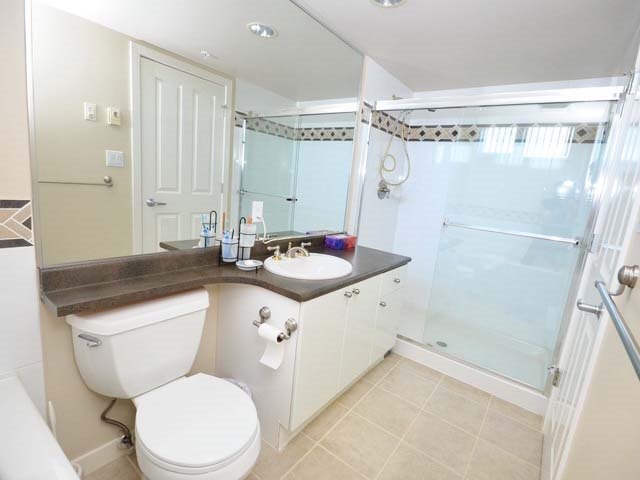 A bathroom, a long vanity beside a glass shower.