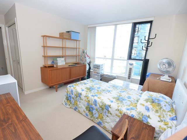 A second bedroom, a bed under the window with shelving along the wall.