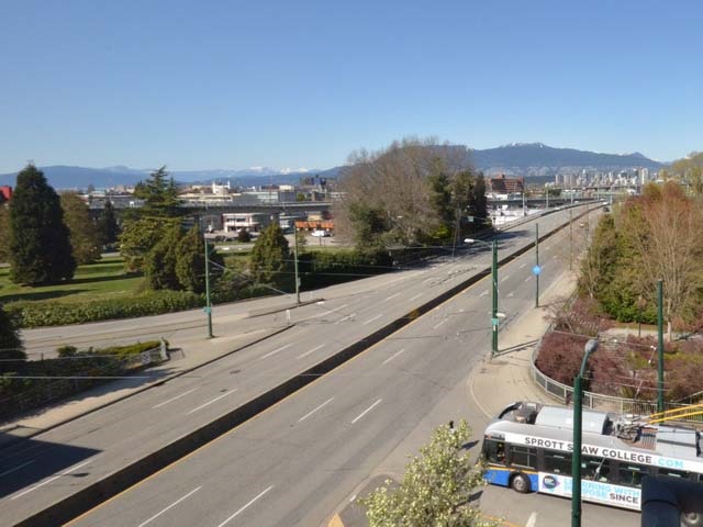 The view west along the street, the rail corridor and the trees running out toward the mountains.