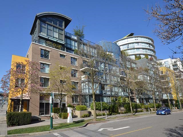 The building from the street, concrete and glass with the curved corner rising behind.