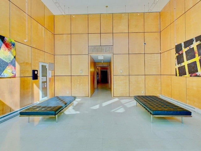 The lobby, panelled walls and benches under a skylight.