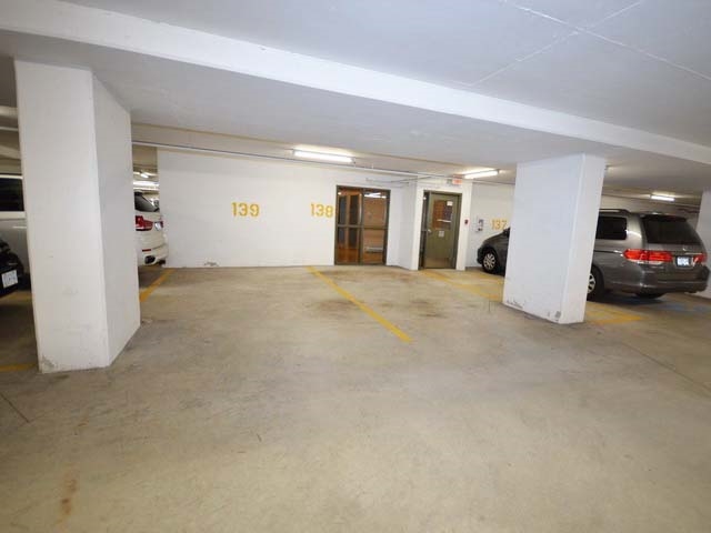 The underground parking, numbered stalls beside the elevator lobby.