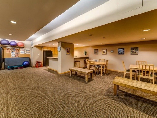 The party room, long tables and benches with a games area beyond.