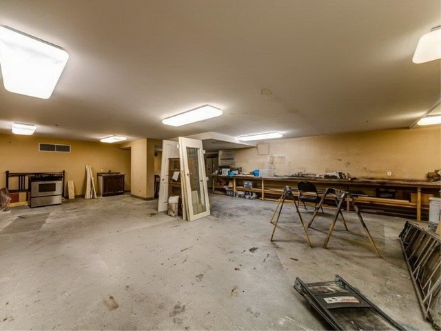 The workshop, benches and tools under the strip lights.