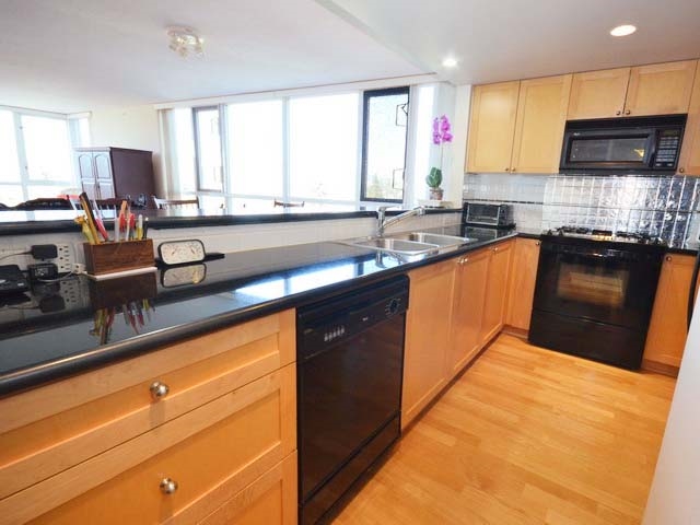 The kitchen counters, a gas cooktop and a wall oven with the cabinets above.