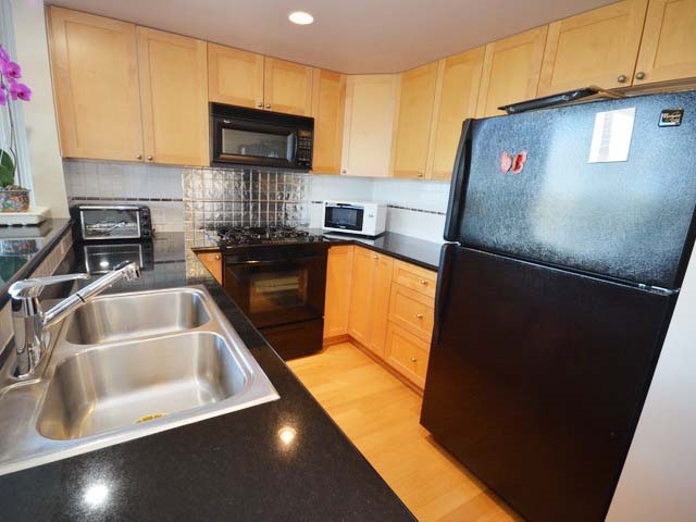 The kitchen sink and appliances at the near end of the run.